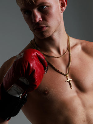 Boxer wearing the gold filled crucifix pendant on a 4mm Franco chain with red training gloves
