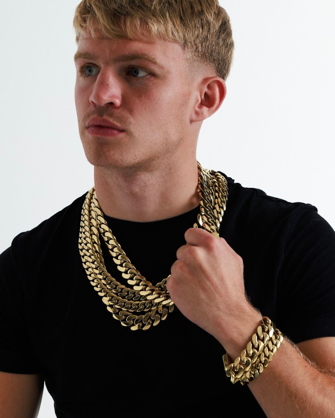 AU social week 1 Sunday. Model in a black t shirt wearing layered gold filled chains