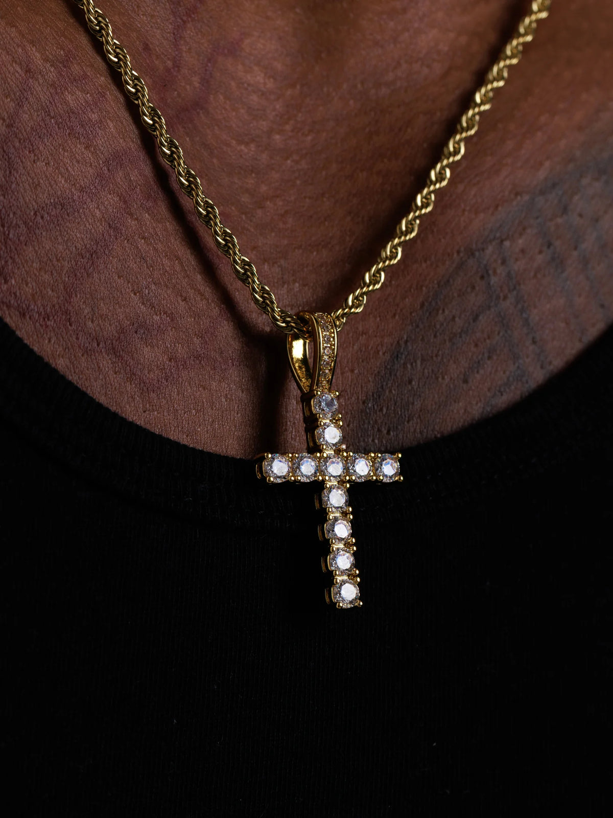 Close view of the stone set cross pendant showing the setting and bail