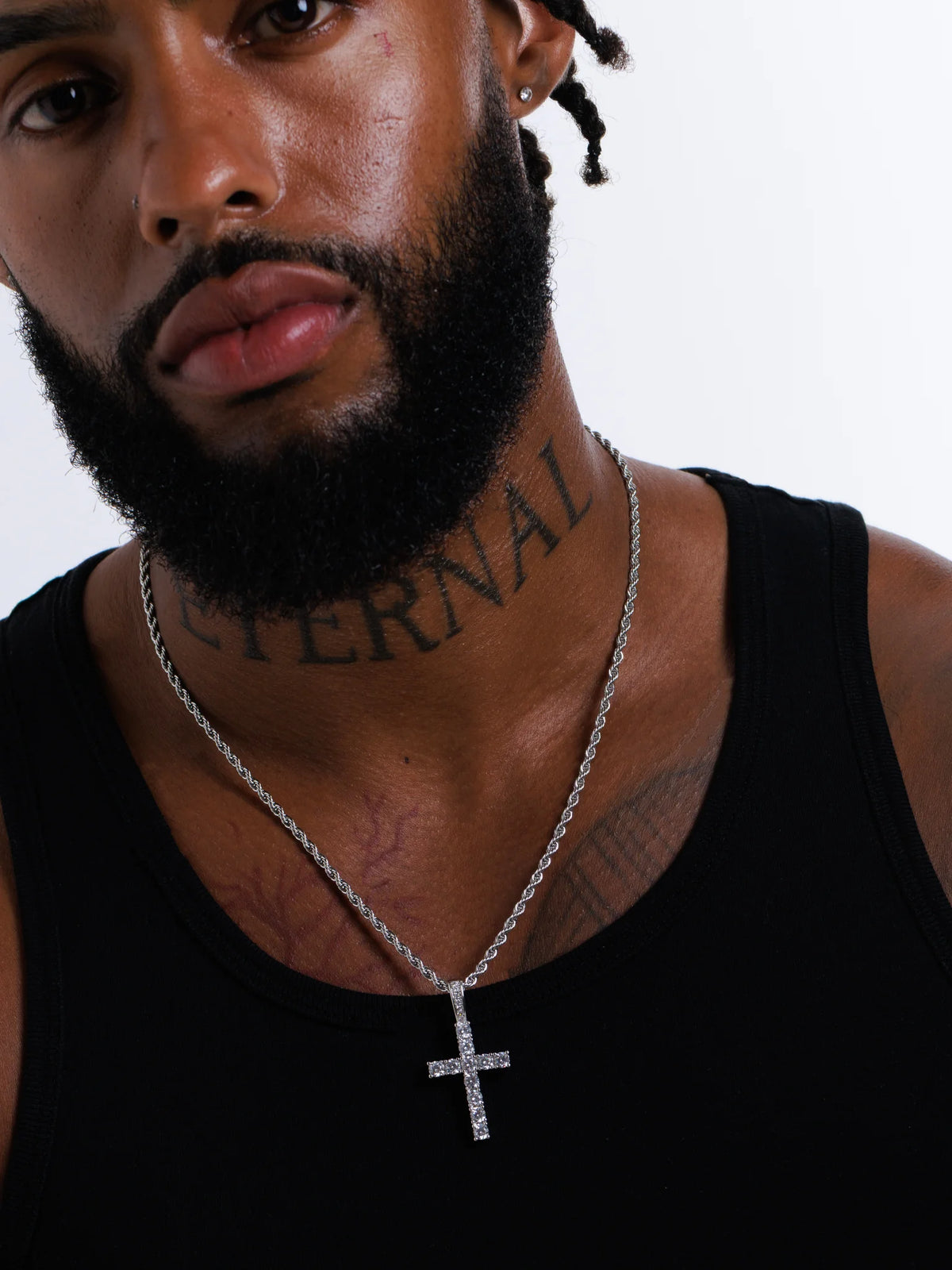 Man wearing the silver stone set cross pendant on a 3mm rope chain with a black vest