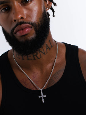 Man wearing the silver stone set cross pendant on a 3mm rope chain with a black vest