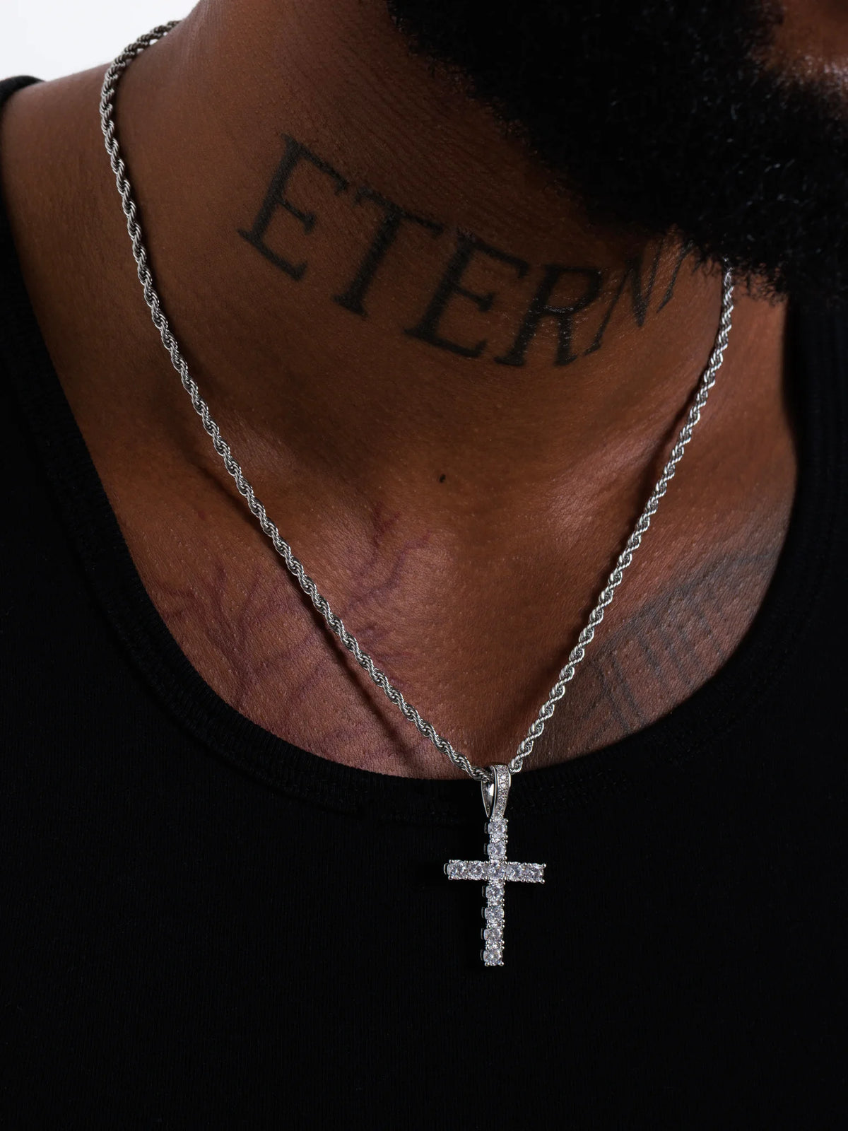 The silver cross pendant on a 3mm rope chain sitting mid chest at the 20 inch length