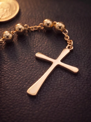 Close detail of the cross and beads on the gold filled rosary bead necklace