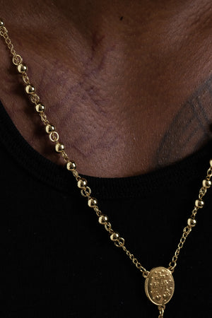 Close view of the gold beads and the oval centre medal on the rosary necklace
