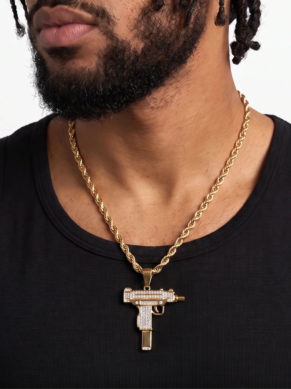 Man wearing the gold filled uzi pendant on a 6mm rope chain with a black vest