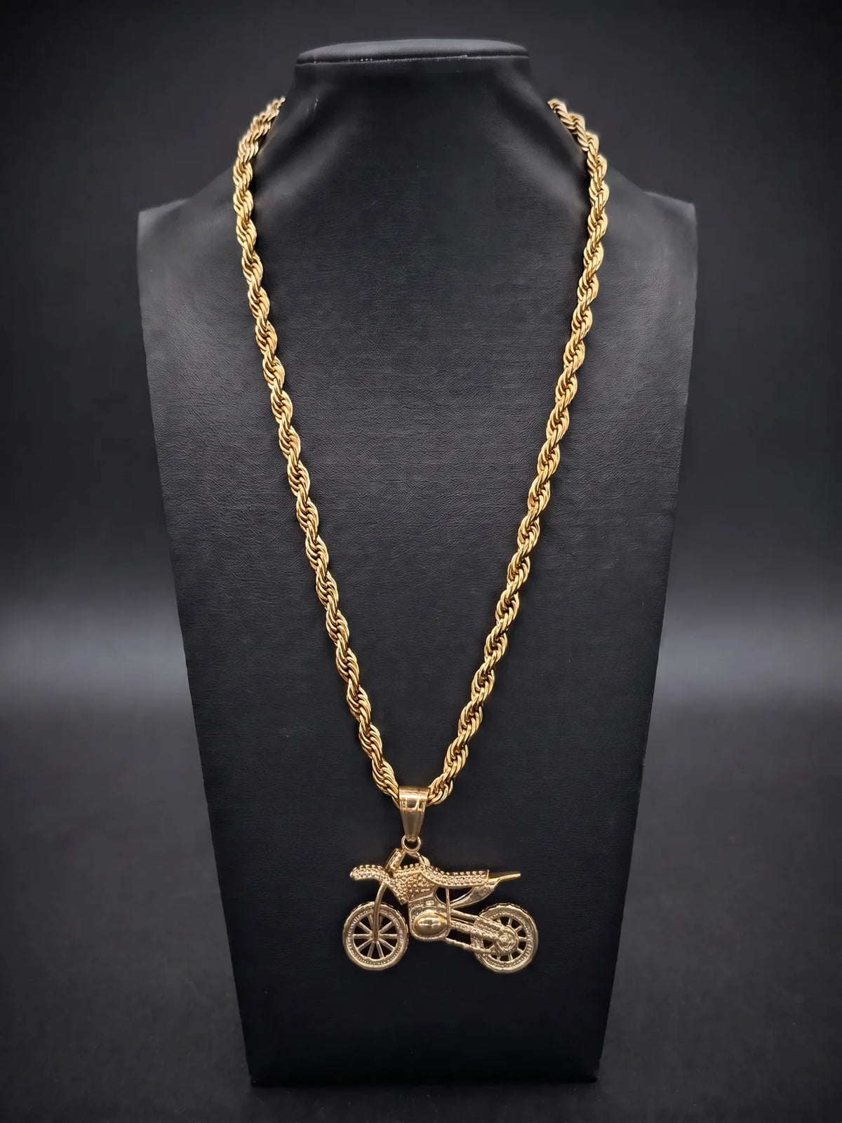 Gold filled bike pendant on a 6mm rope chain displayed on a black bust