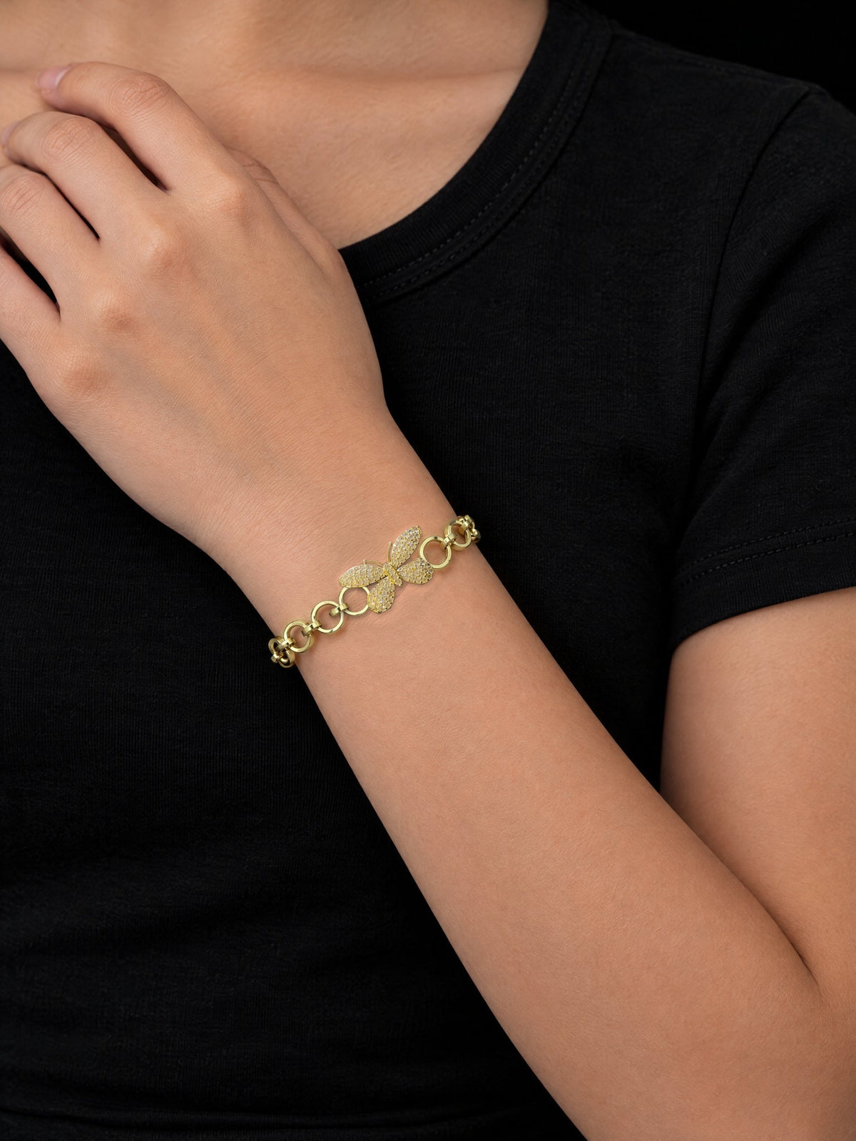 Girl with her hand at her collarbone wearing the Girls Diamond Butterfly Charm Belcher Bracelet Gold Filled